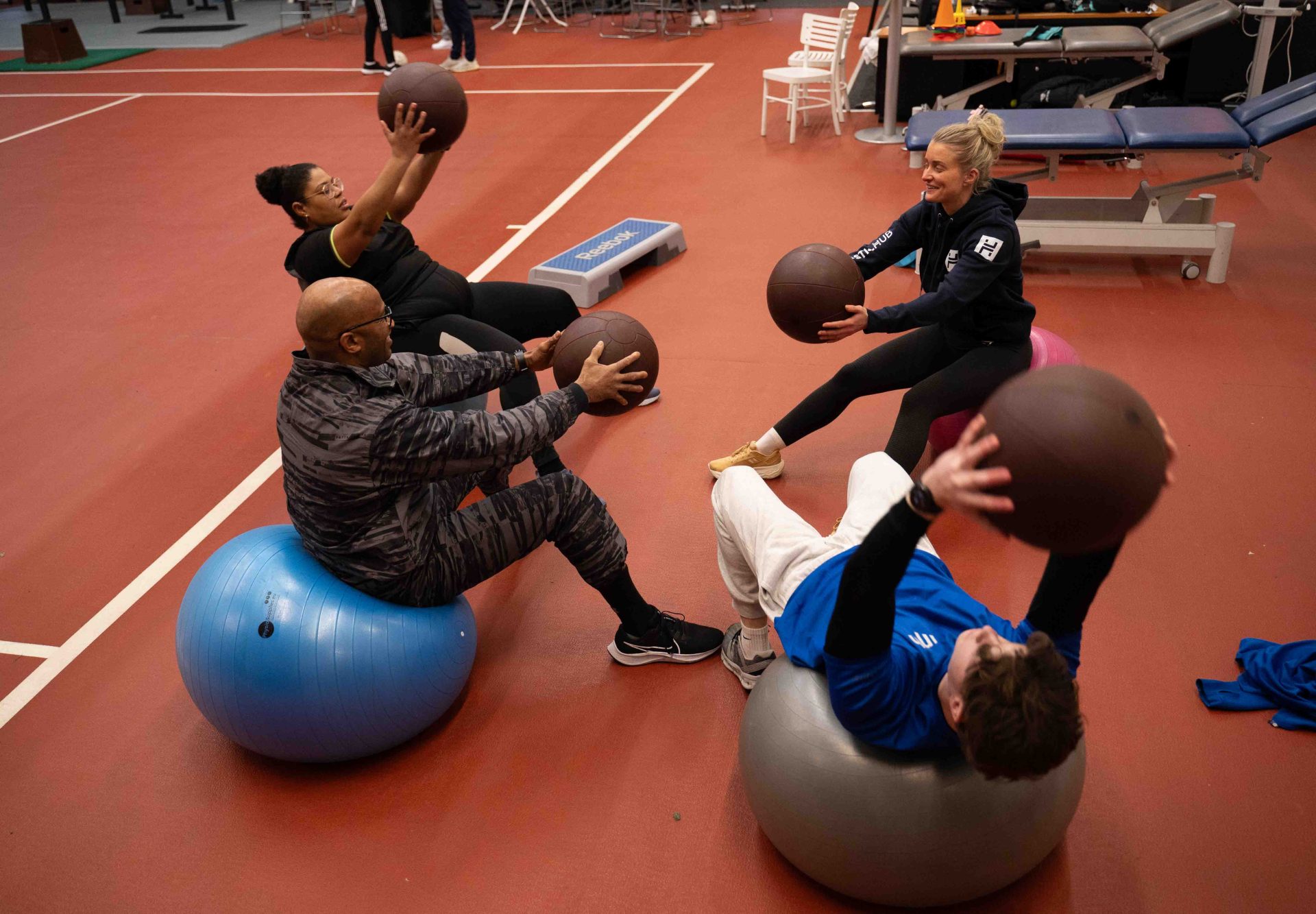 Groep sport op fitnessballen met medicijnballen tijdens core-training in de sportschool