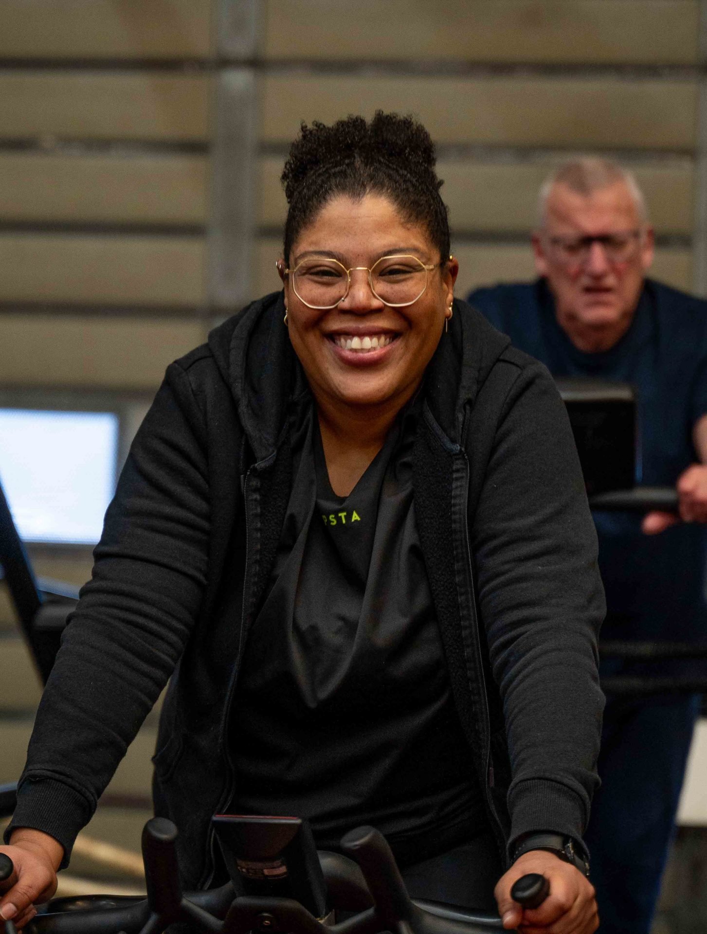 Lachende vrouw traint op hometrainer in de sportschool